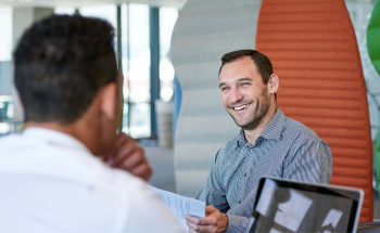 Men discussing papers in corporate setting